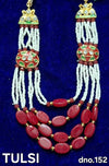 Bead necklace with white strands, red oval beads, and green-gold deity pendant