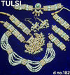 Gold-toned kundan jewellery set with green pendant necklace and dangling earrings