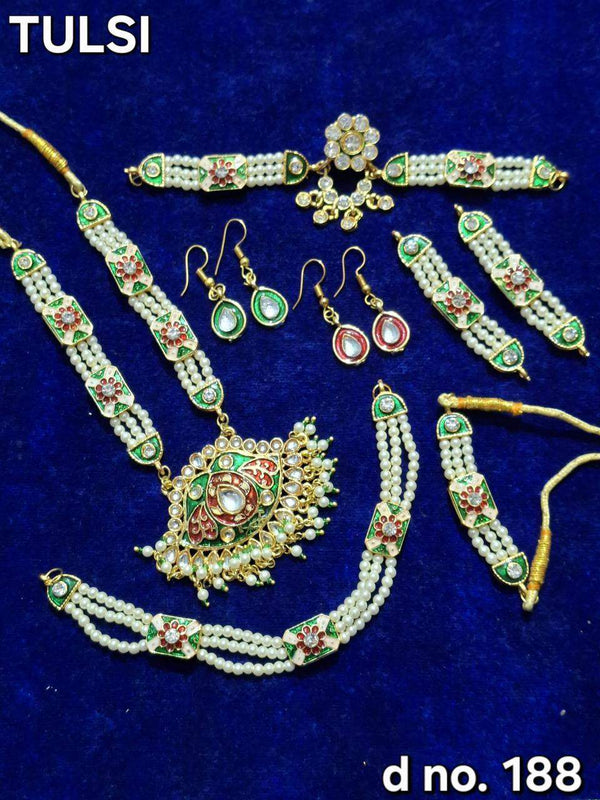Temple jewelry set with green enamel, red stones, pearl beads, necklace, earrings, and bangles