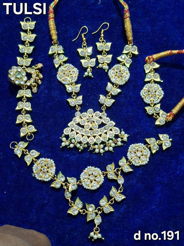 Gold-tone kundan-style shringar jewellery set with necklace, earrings, and pendant ornaments