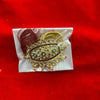 Decorative idol ornament with gold trim and gem-like stones, with red tassel