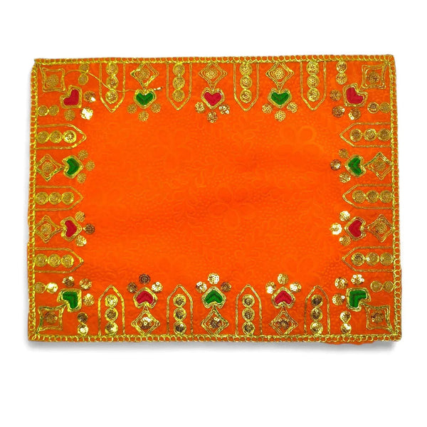 Orange velvet pooja cloth with gold and green embroidered border, centered motifs