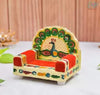 Decorated wooden peacock throne seat with colorful painted back and red armrests