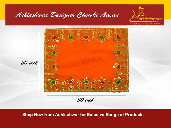Orange velvet pooja cloth with gold and green embroidery framing the center panel