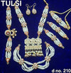 Gold-tone shringar set with layered white bead necklace, red teardrop stones, dangle earrings