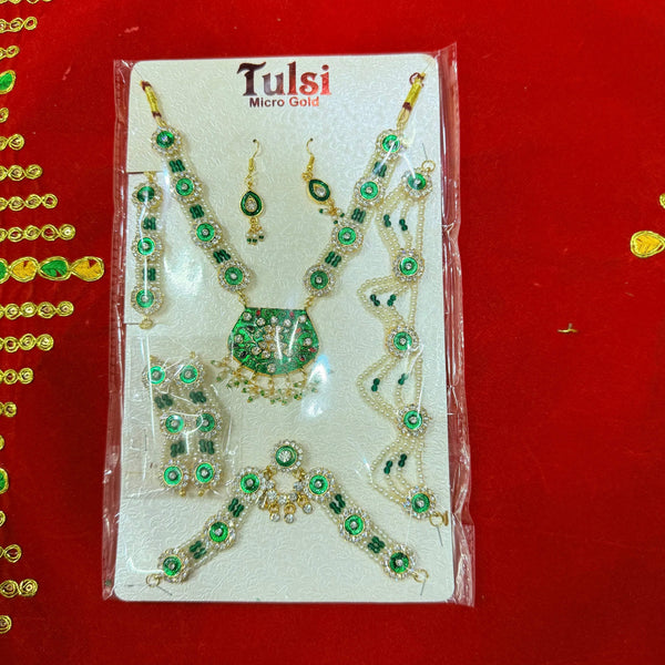 Traditional jewelry set on display card with green stones, pearls, and matching earrings