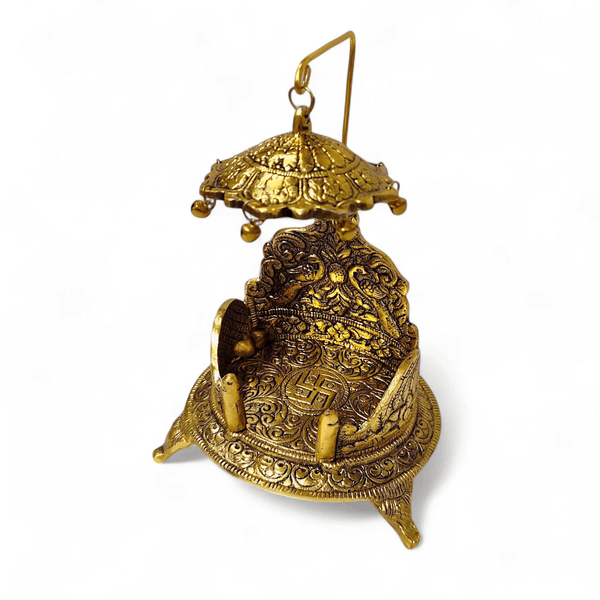 Antique gold singhasan side view with hanging canopy and engraved seat back