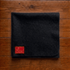 Black woolen square meditation mat with red label patch and stitched border