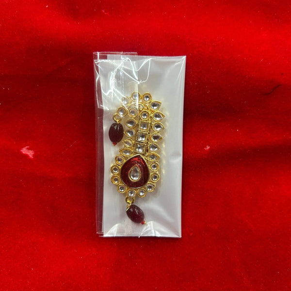 Gold puja ornament with peacock motif and red bead drops, in clear plastic pack