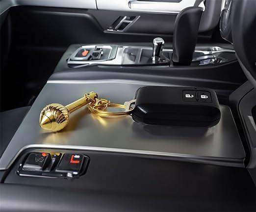 Gold-toned gada keychain locket resting on car center console