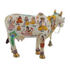Handcrafted cow idol, white with colorful painted figures, gold horns and hanging bell
