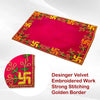Pink velvet pooja asan with golden border and green-gold embroidered work.