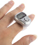 Silver digital finger tally counter ring on a hand, circular button on the side