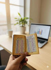 Pocket panchang book held open, showing printed calendar tables