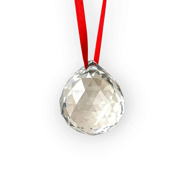 Faceted clear crystal hanging ball with red ribbon, centered view