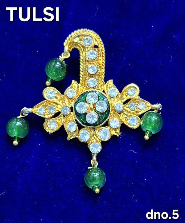 Golden jeweled puja ornament with green bead accents and round stones