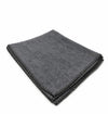 Dark gray wool meditation mat, neatly folded with textured surface and stitched edge