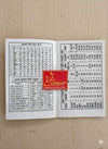 Open paperback astrology book with printed charts and tables on two pages