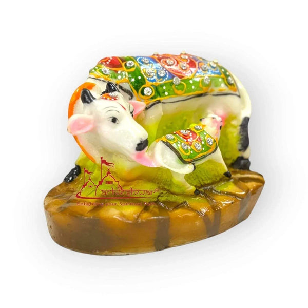 Decorative cow and calf figurine with jeweled multicolor cloth on a brown base