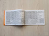 Open devotional booklet with printed tables and text on two pages