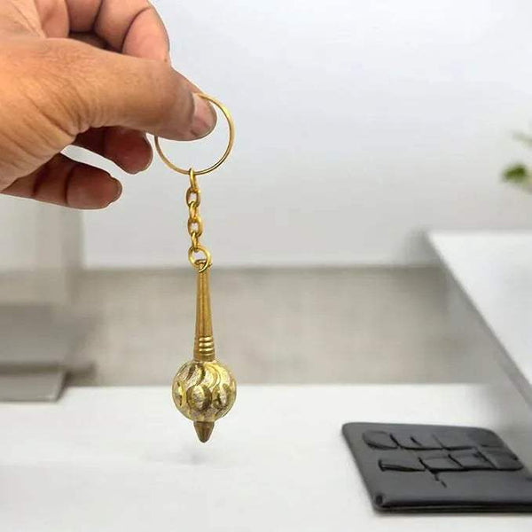 Brass gada keychain held in hand with circular ring and chain, pointed spherical pendant
