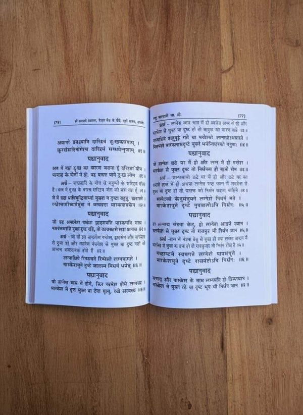 Open astrology guide book showing two columns of printed Hindi text on cream pages