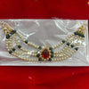 Beaded garland decoration with red teardrop centerpiece, pearl strands, and green accents