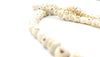 Close-up of off-white tulsi mala beads with engraved text