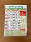 2026 Hindi calendar poster with red and green date grid on wooden surface