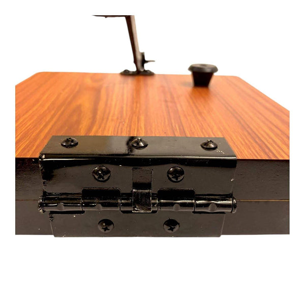 Close-up of wooden roti press top with black hinge bar and screw fixtures.