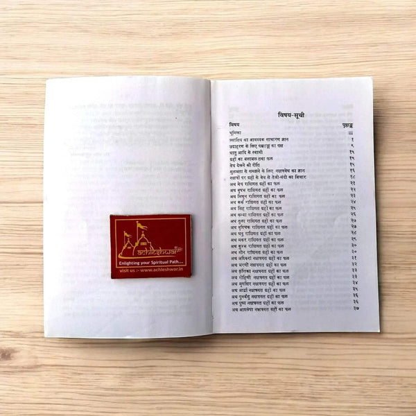 Open paperback Hindi book showing two pages of printed text and a red logo