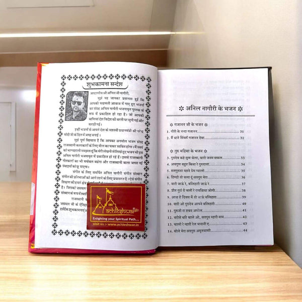 Open Hindi bhajan book showing printed text and decorative border page.