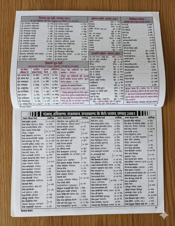 Hindu panchang booklet open pages with printed date tables and Hindi text