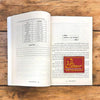 Open Hindi numerology book with a data table and red spiritual logo bookmark.