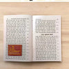Hindi book spread with two densely printed scripture pages and small icons
