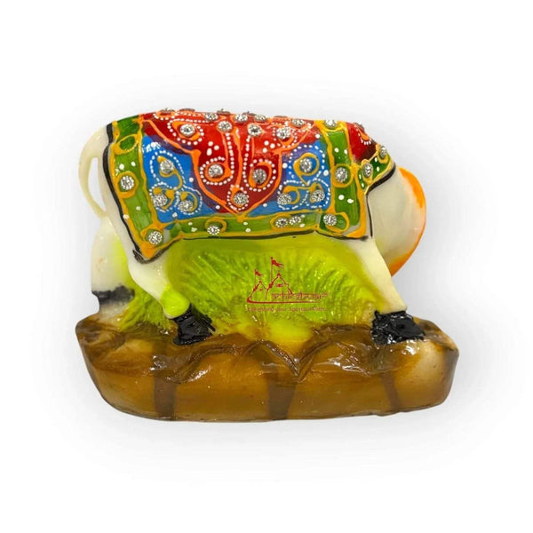 Back view cow and calf figurine with multicolored cloth draped over the green body