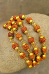 Rudraksha bead mala with golden caps, stacked strands of brown and gold beads.