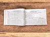 Open Gujarati panchang book showing dense printed calendar tables