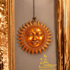 Copper sun face wall hanging with radiating flame-style rays and vertical emblem on forehead.