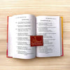 Open devotional book with dense printed text on two facing pages