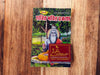 Religious book with illustrated deity on cover, green foliage border, and red title