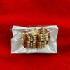 Beaded traditional decoration with red, gold, and white beads in a clear pack