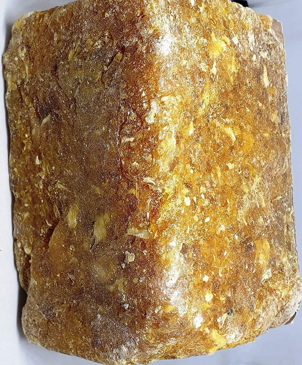 Brown-golden loban dhoop resin block with speckled texture on a flat face