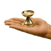 Brass diya oil lamp held in hand, flared bowl and stepped pedestal base