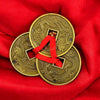 Gold lucky coins with red ribbon loop on two coins