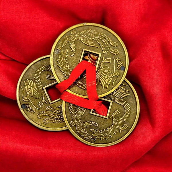 Gold lucky coins with red ribbon loop on two coins