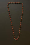 Rudraksha bead mala with golden caps, dark red-brown bead strand with gold spacers.