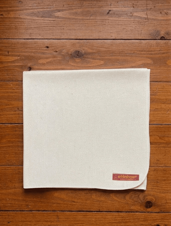 Off-white woolen meditation mat with stitched hem and brand tag on corner