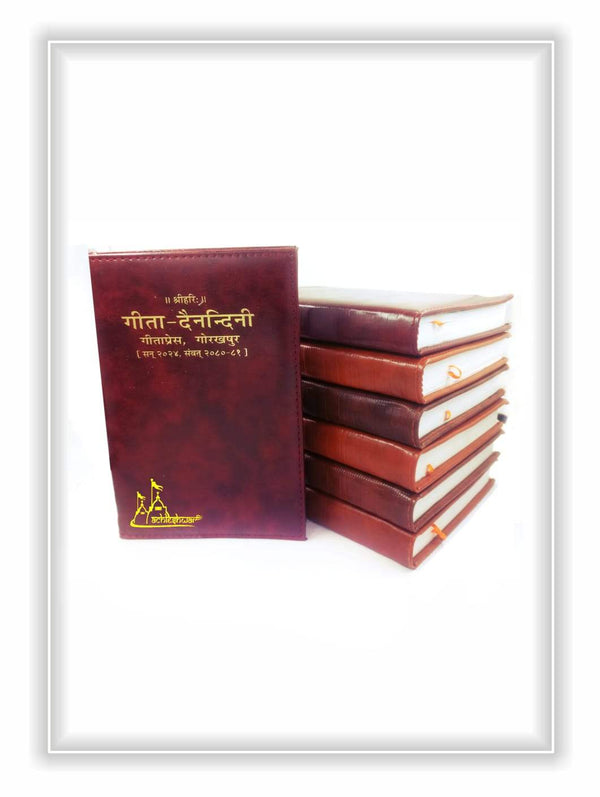 Burgundy diary cover beside stacked books with gold-edged pages