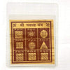 White-bordered Bhojpatra yantra card with gold Devanagari symbols in a centered frame